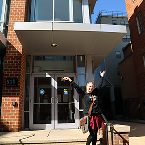 UMB student standing on the steps of Fayette square smiling