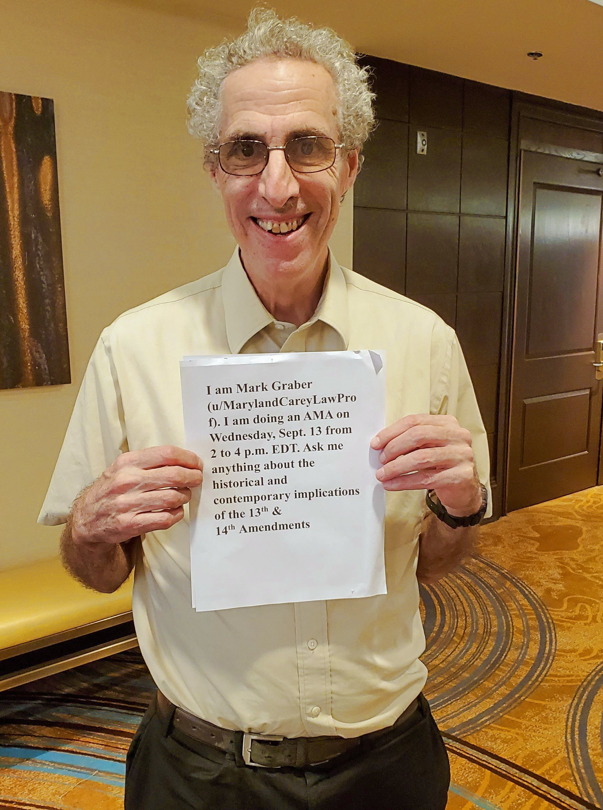 USM Regents Professor Mark A Graber holding a piece of paper showing his Reddit Ask Me Anything date and time