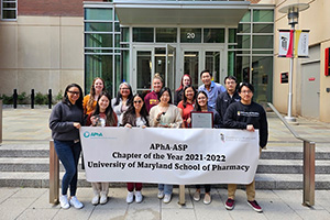 School of Pharmacy Students posing with a APhA-ASP banner that states they won chapter of the year