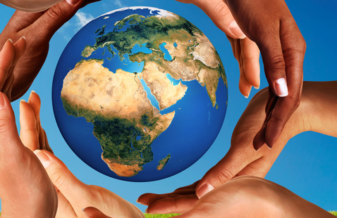 world globe encircled by hands