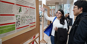 Two people looking at a poster during a poster session.