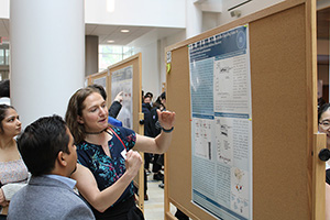 Attendees at the Frontiers at the Chemistry-Biology Interface Symposium discuss a research poster. 