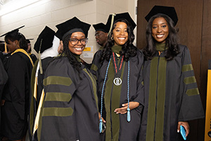 Three PharmD graduates at the UMB graduation ceremony.
