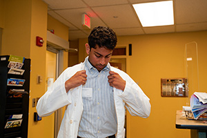 A new student tries on a white coat.