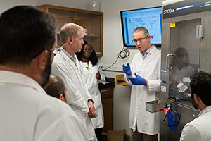 Scientists gather in a lab during the tablets and capsules short course.