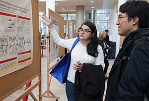 Two people look at a poster during a poster session.