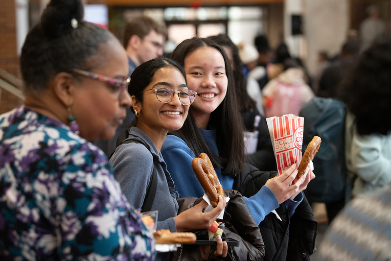 photo of students smiling, holding soft pretzels