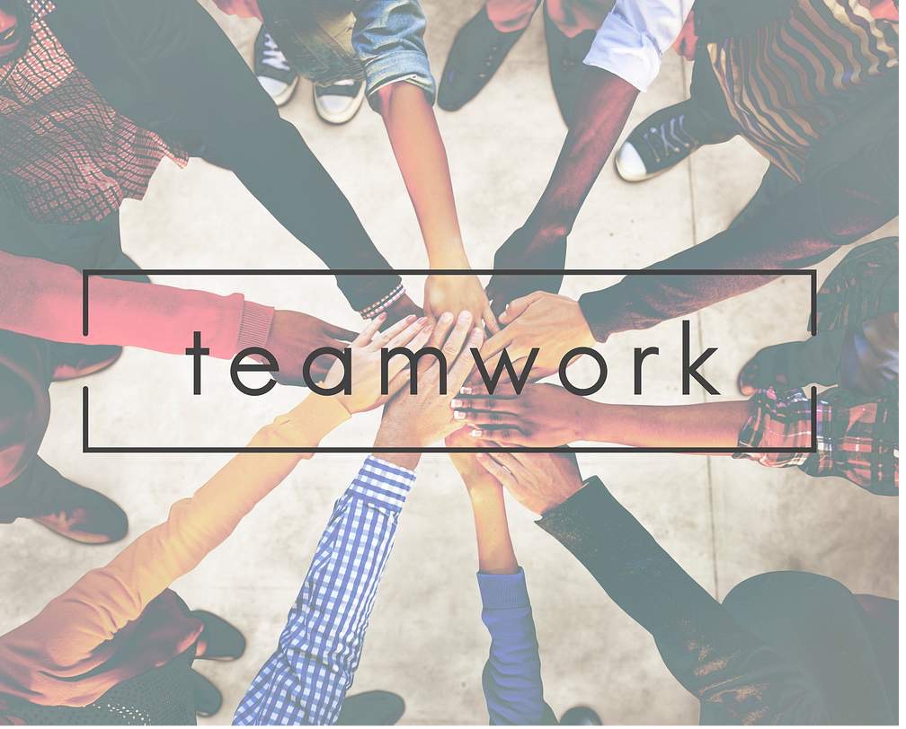 word teamwork on top of photo with hands in a circle