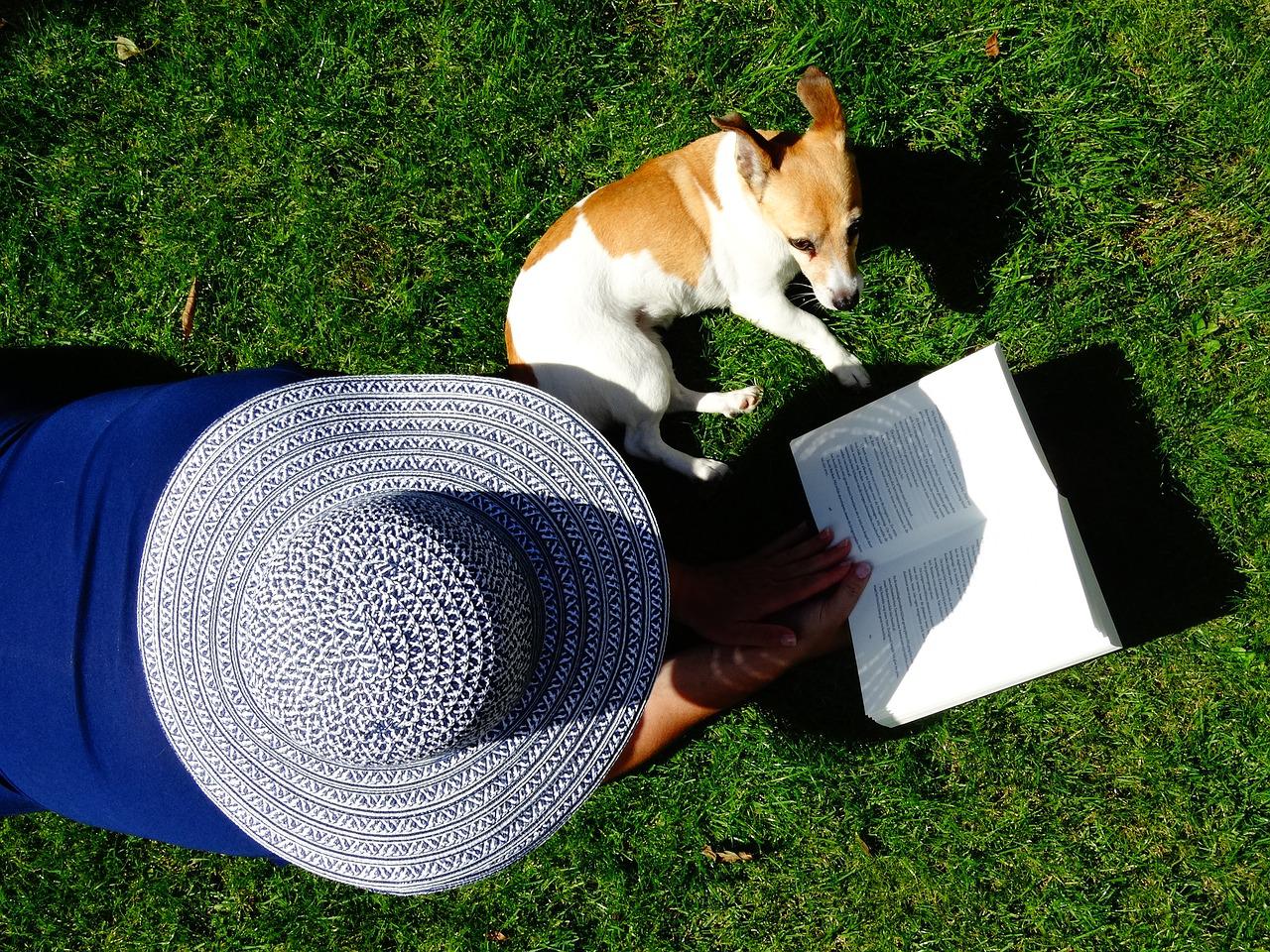 Woman reading book with puppy