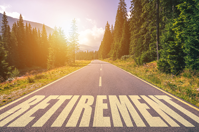 Retirement spelled out on a road with the sun shining in the background