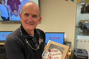 Larry Gonzales holds a cake saying Happy Retirement Larry