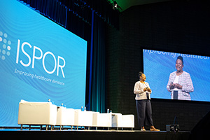 Eberechukwu Onukwugha speaks on stage at the ISPOR annual meeting.