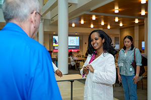 A student tries on a white coat.