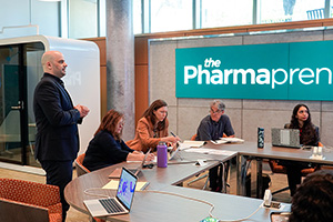 A student presents in front of a panel in the Pharmapreneur's Farm