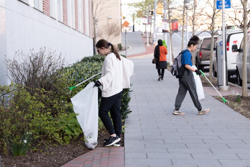 Image of people on sidewalk collecting litter. 