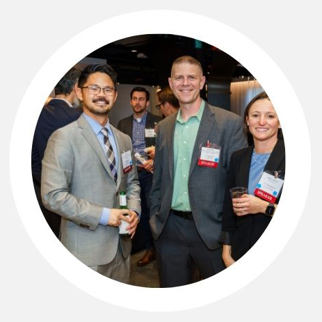 Photo of three people looking at the camera and smiling at a networking event