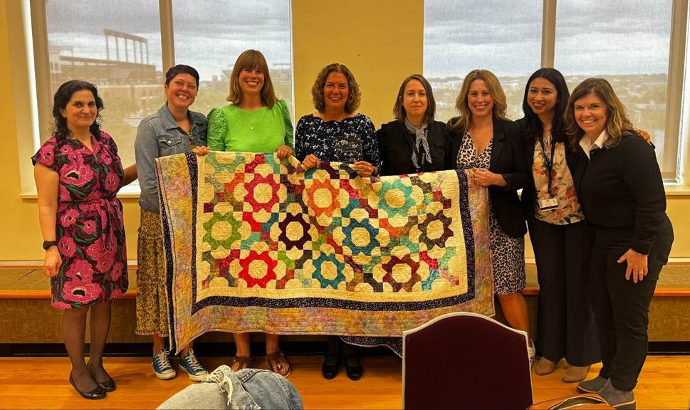 Photo of group holding quilt