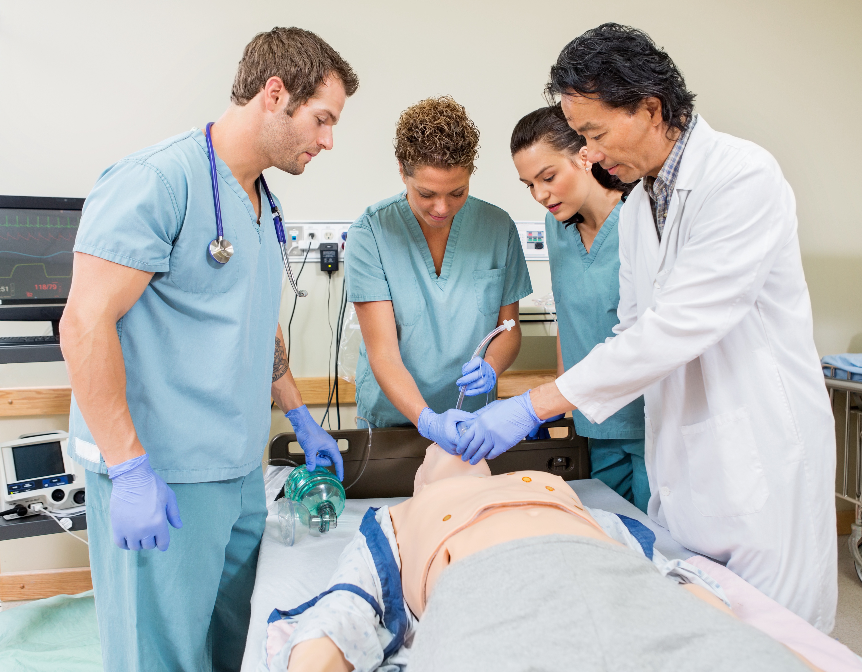 doctor and students standing over mannequin patient