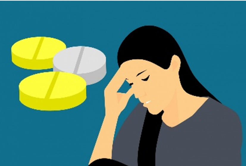 Three pills and a woman touching her head seeming to be in pain