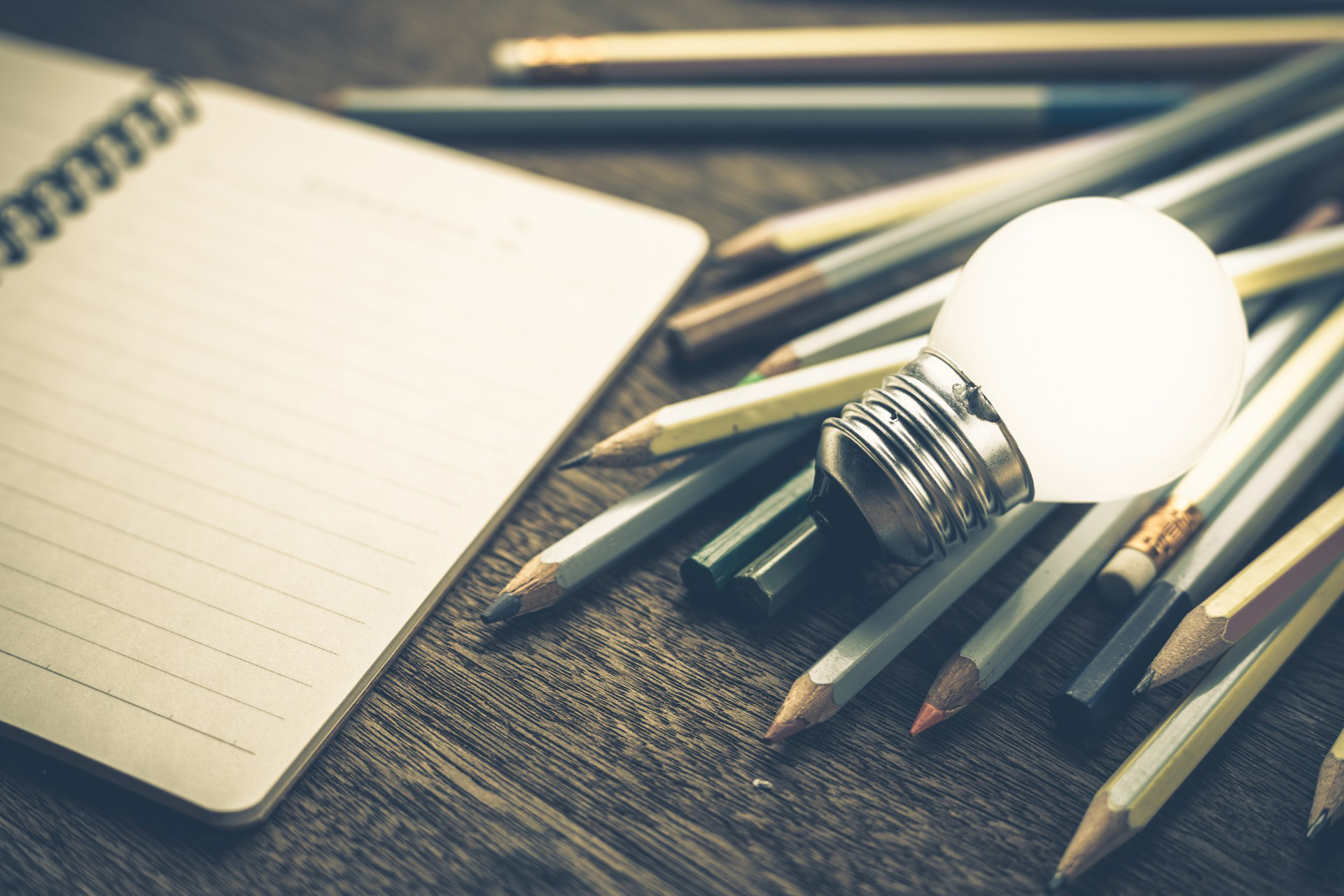 notebook with pencils and a lightbulb