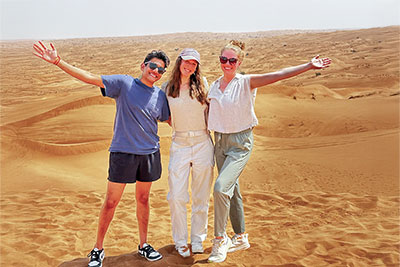 Vraj Patel at left, with two colleagues, standing in the desert in Zambia.