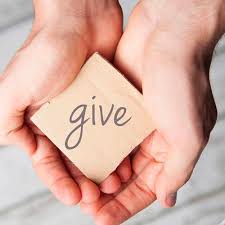 hands holding a paper that says give