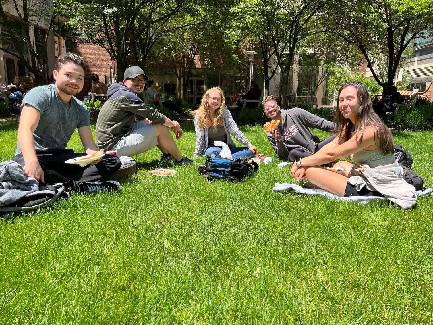Students sitting on the UMSON courtyard lawn on a beautiful day.