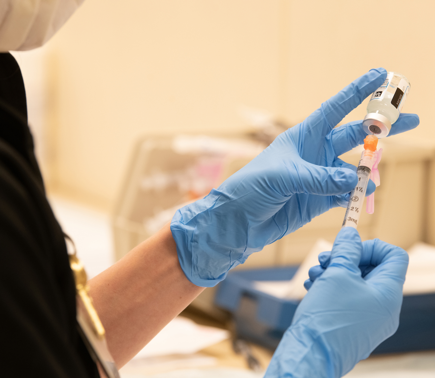 photo of gloved hands holding a syringe