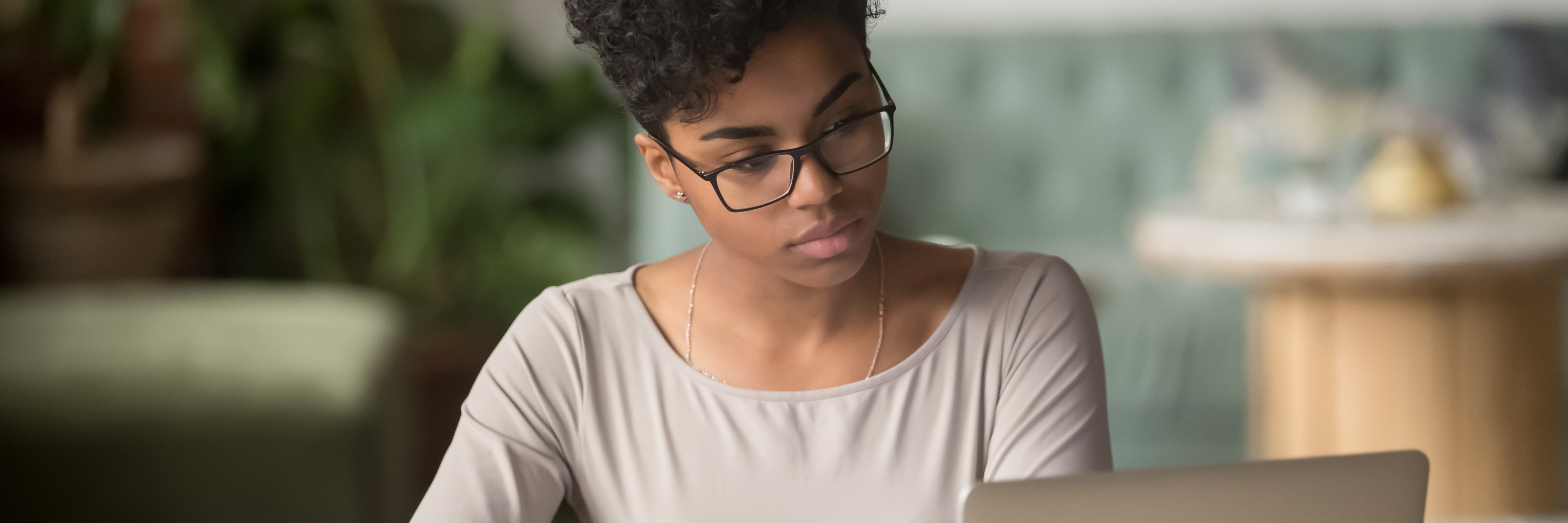 black female with glasses studies on a screen