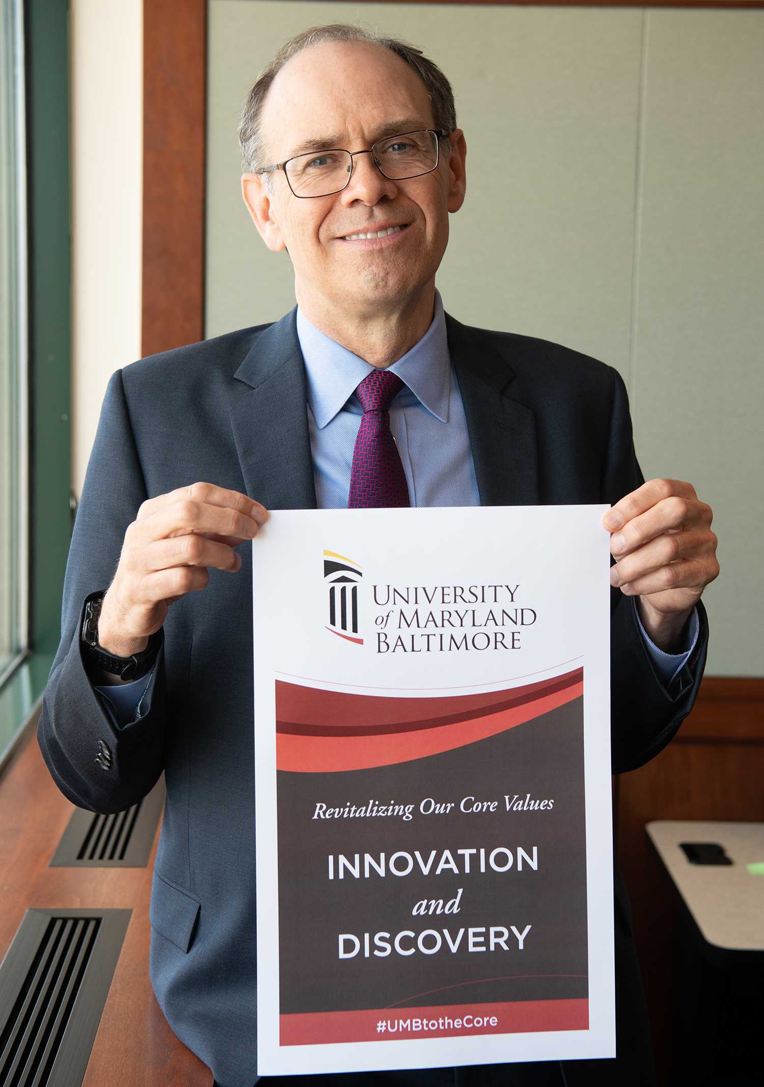 James Hughes holding Innovation and Discovery sign