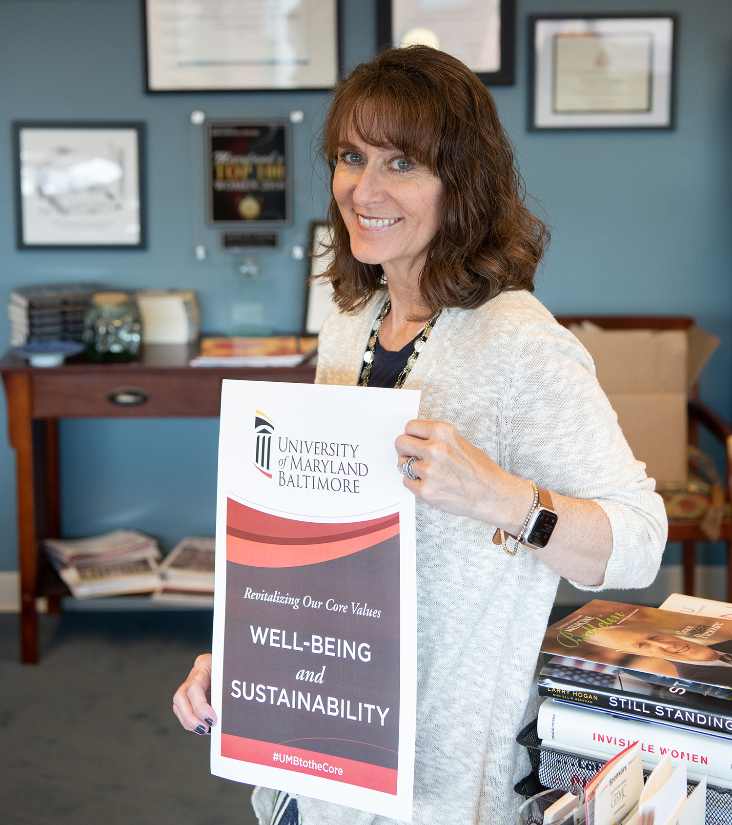 Jennifer Litchman holding Well-Being and Sustainability sign