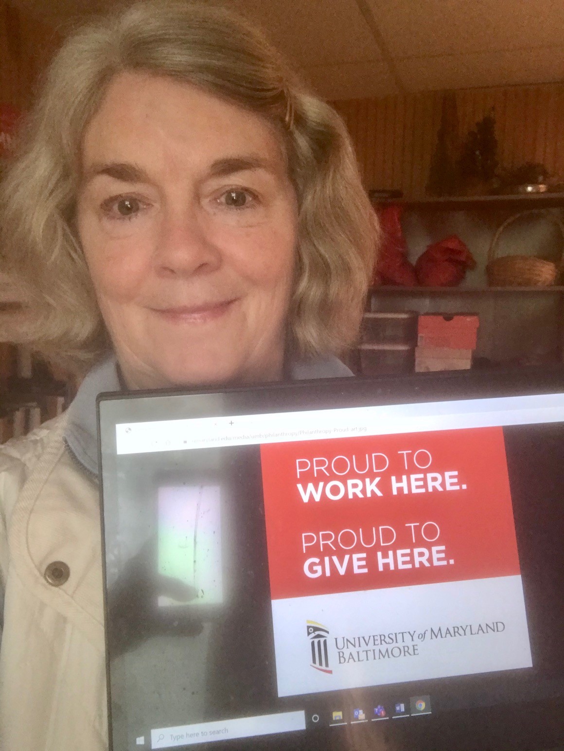 Photo of Cynthia Sikorski holding Proud to Work Here, Proud to Give Here sign