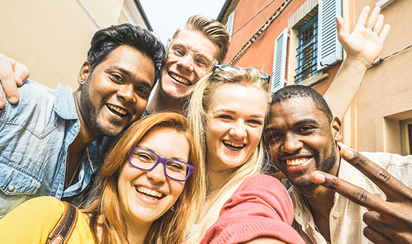 Diverse group of young people smiling and taking a group photo