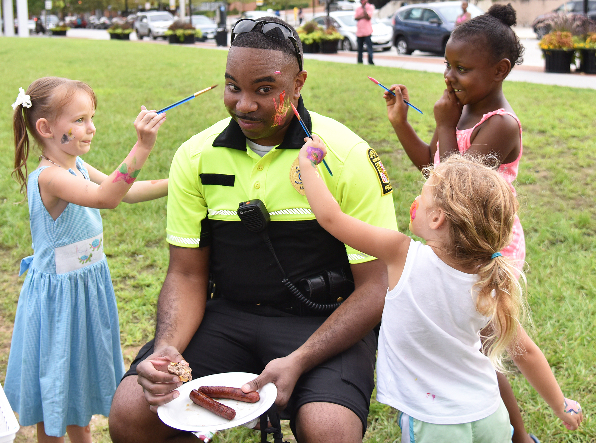UMBPD officer has his face painted by 3 children.