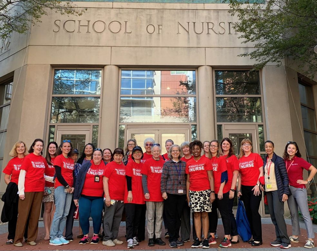 UMSON faculty and staff wearing red in front of the building