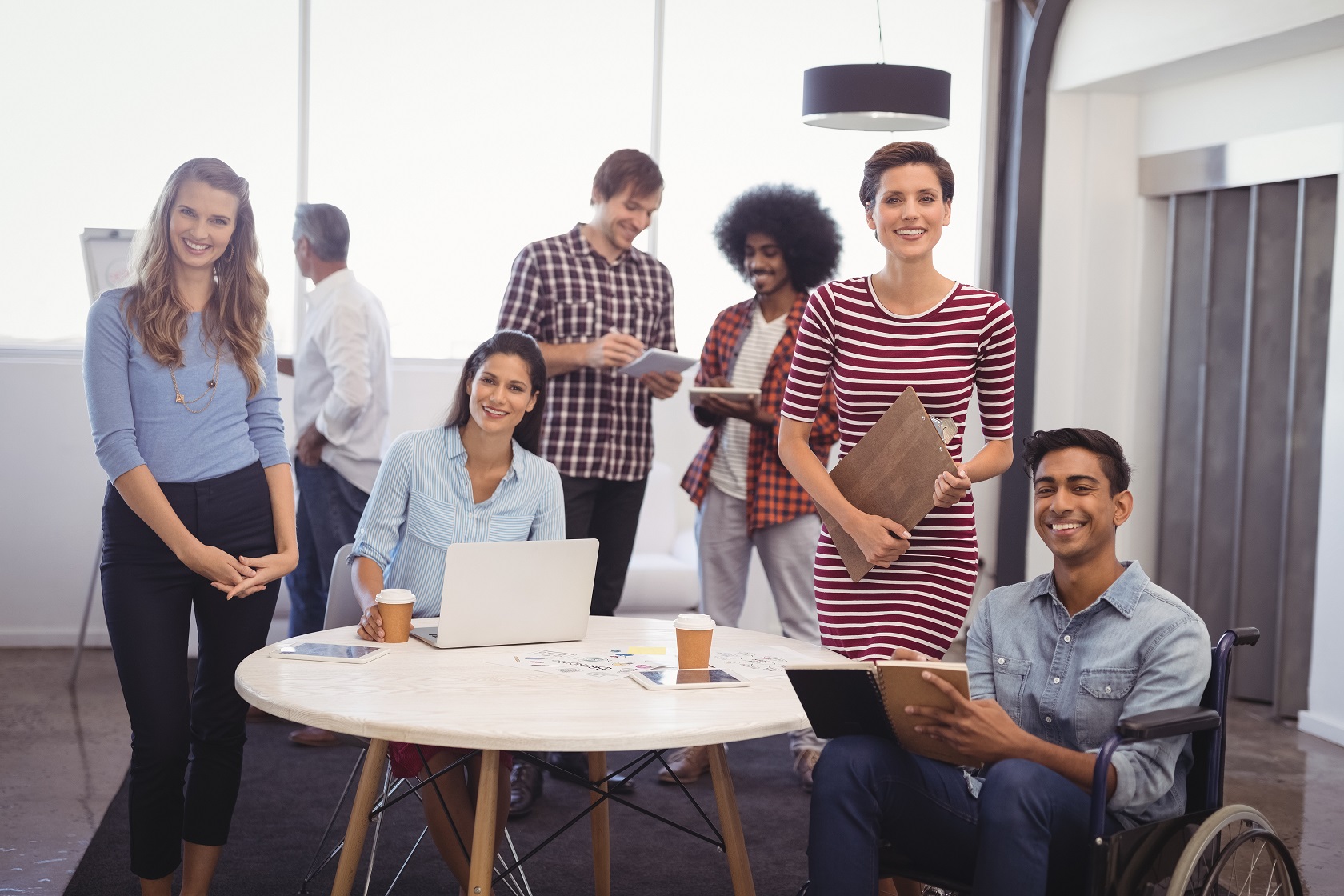 this is an image of a group of people smiling and sitting around a table.