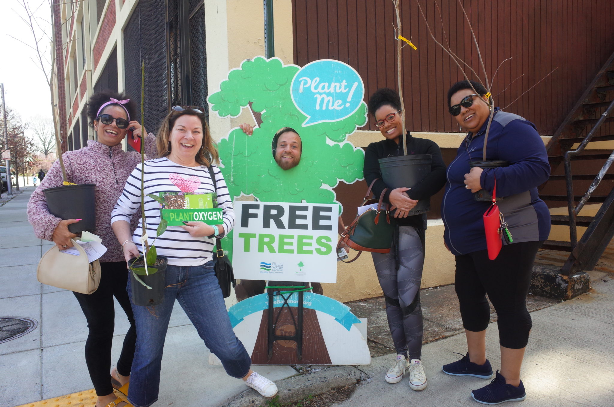Image from Blue Water Baltimore's Website for their Tree Giveaway. Five people posing with a 
