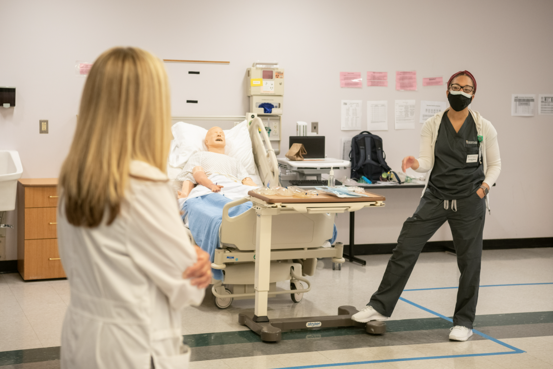 student and instructor in clinical simulation lab wearing masks