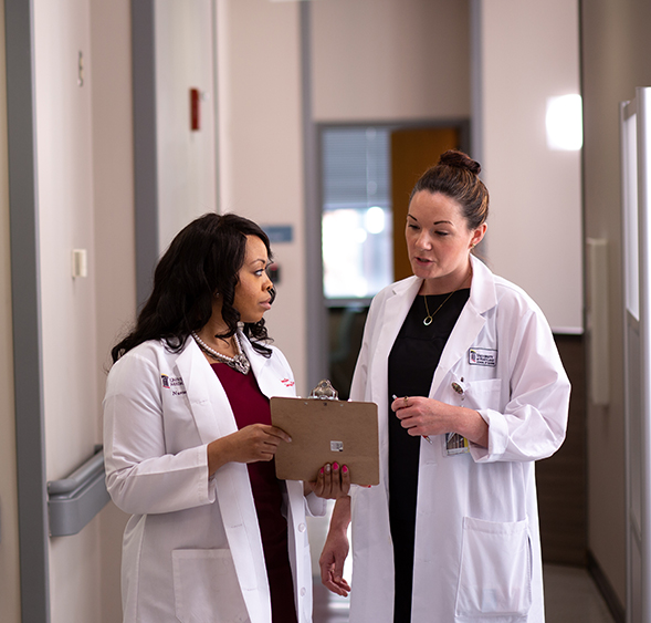Two nurse practitioners converse in a practice setting