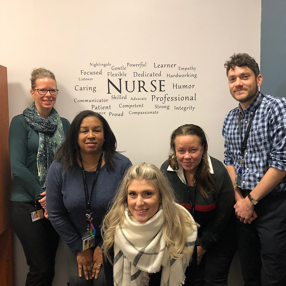 Registration and Clinical Placements team in front of nurse decal