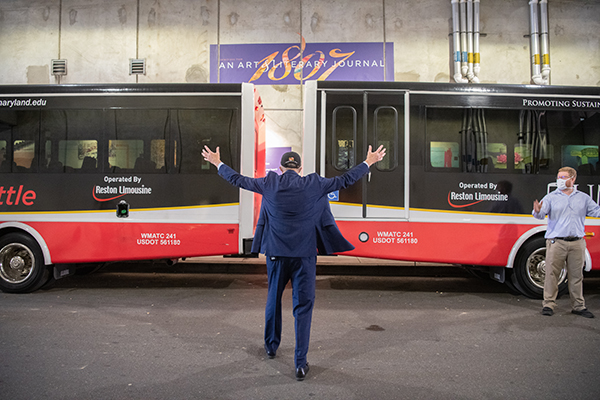 Dr. Jarrell with open arms directing buses to move