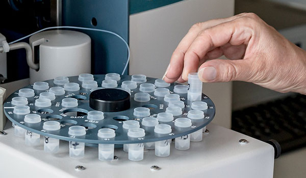 Researcher places test tubes in centrifuge.