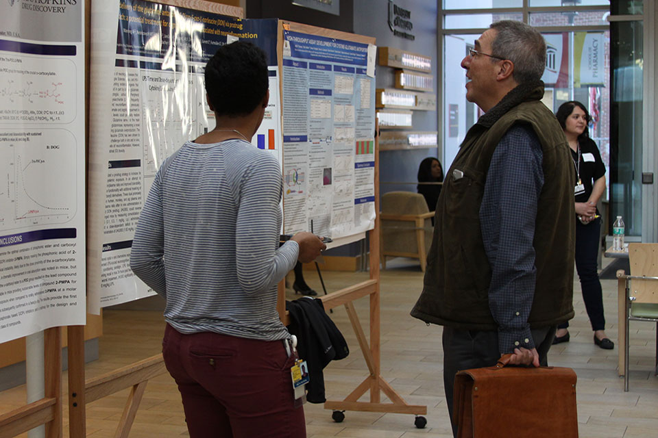 Researchers discuss study during poster session.