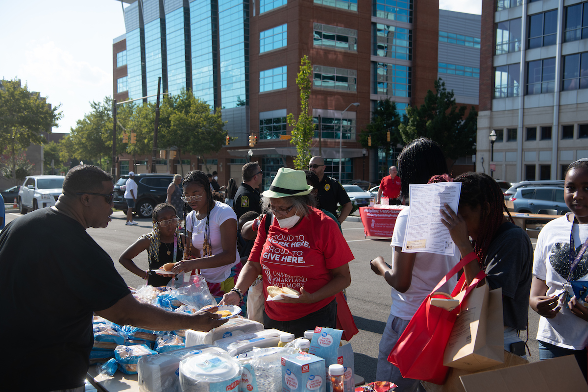 Community members help themselves to free hot dogs and hamburgers at National Night Out