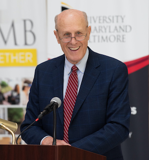 Bruce Jarrell smiles, standing behind podium