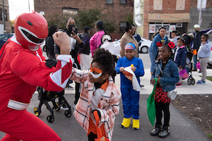 Red Power Ranger makes a muscle as children look on at CEC Halloween event