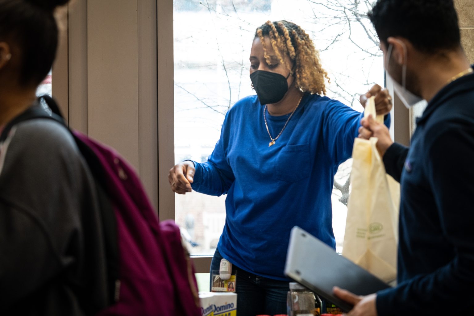 Jolé Ruff of UMB Student Affairs hands out bags of food to students during a pop-up pantry event in the School of Nursing lobby in February. 