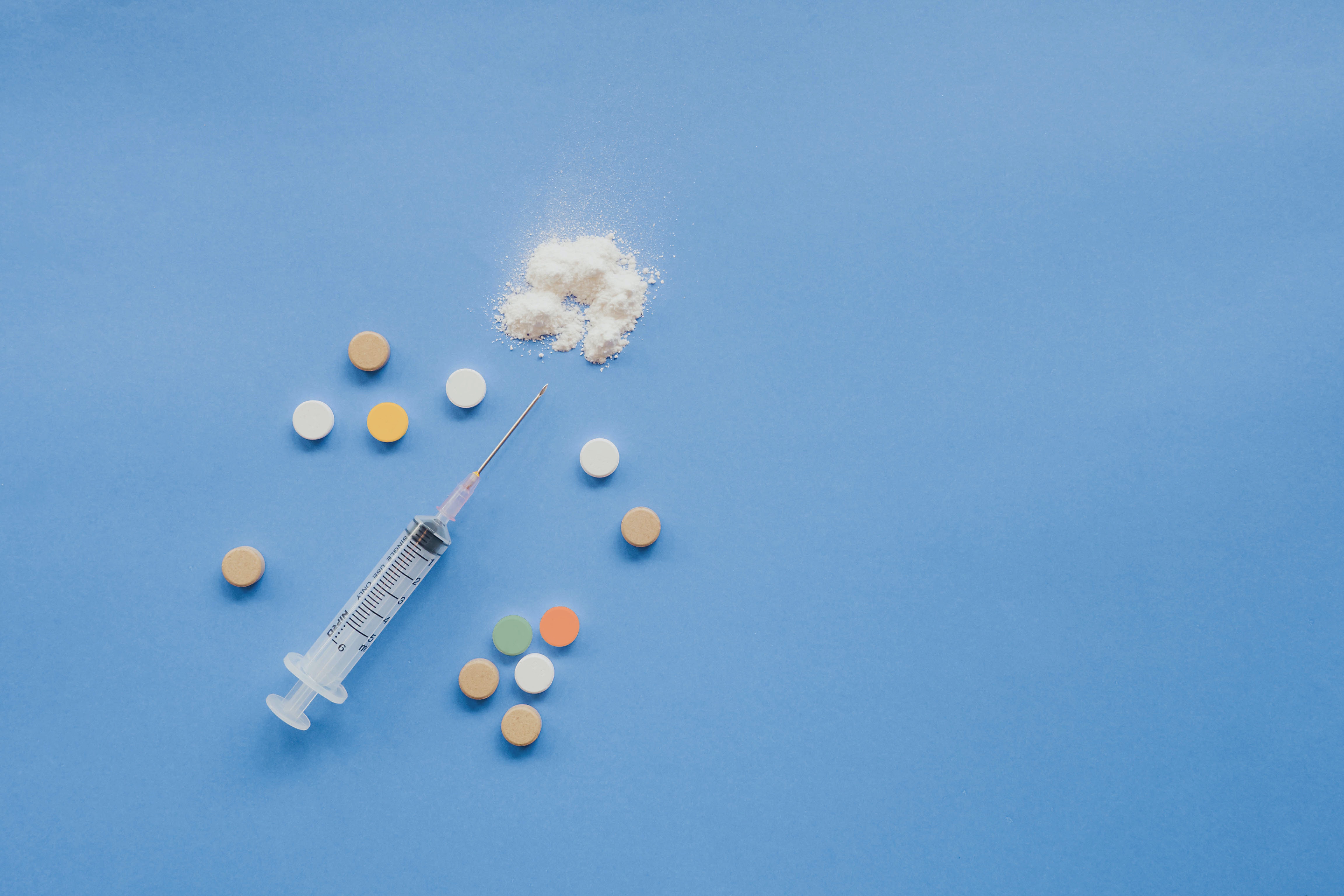 Pills, syringe, and a white powder