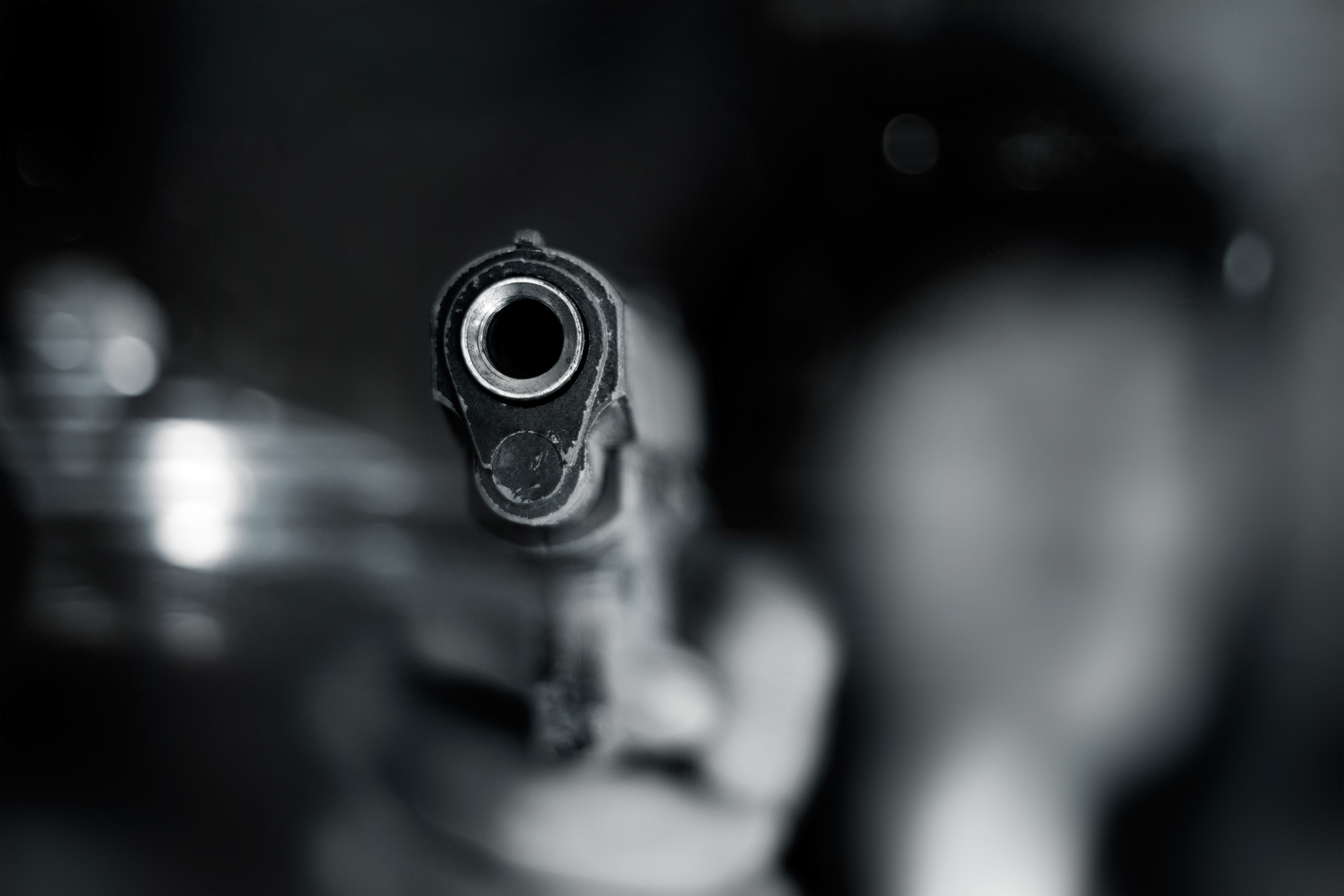 black and white image of hand holding gun