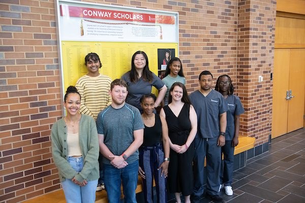 Conway Scholars standing before a Conway Scholarshp sign